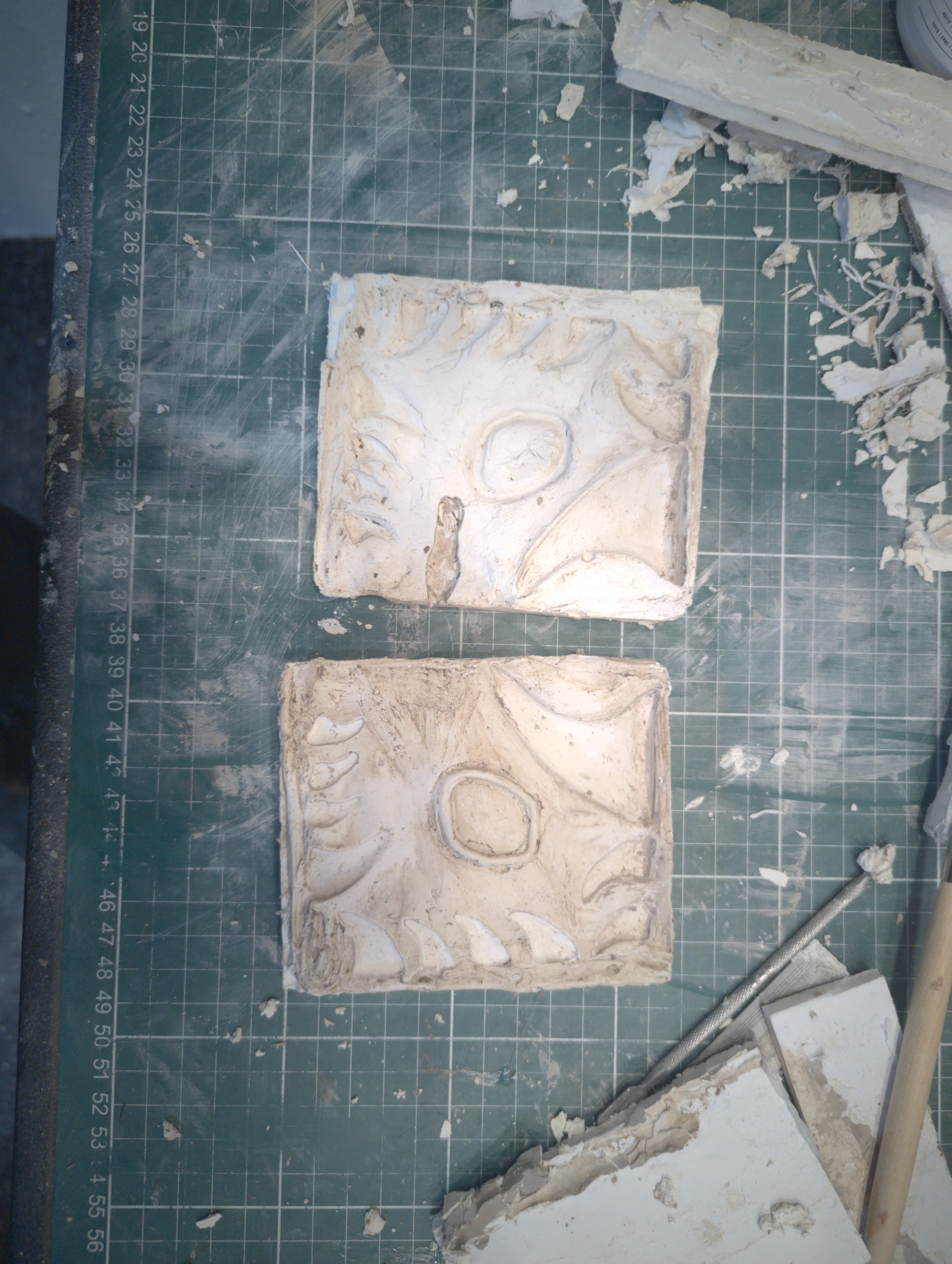 Plaster molds of smaller detail pieces on cutting mat